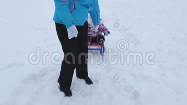 在冬天，年轻<strong>的</strong>母亲在雪道上雪橇上滚动小婴儿。 <strong>孩子</strong>顽皮，坐在雪橇上<strong>哭泣</strong>